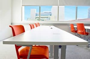 Classroom with Flexible Orange Chairs and White Desks