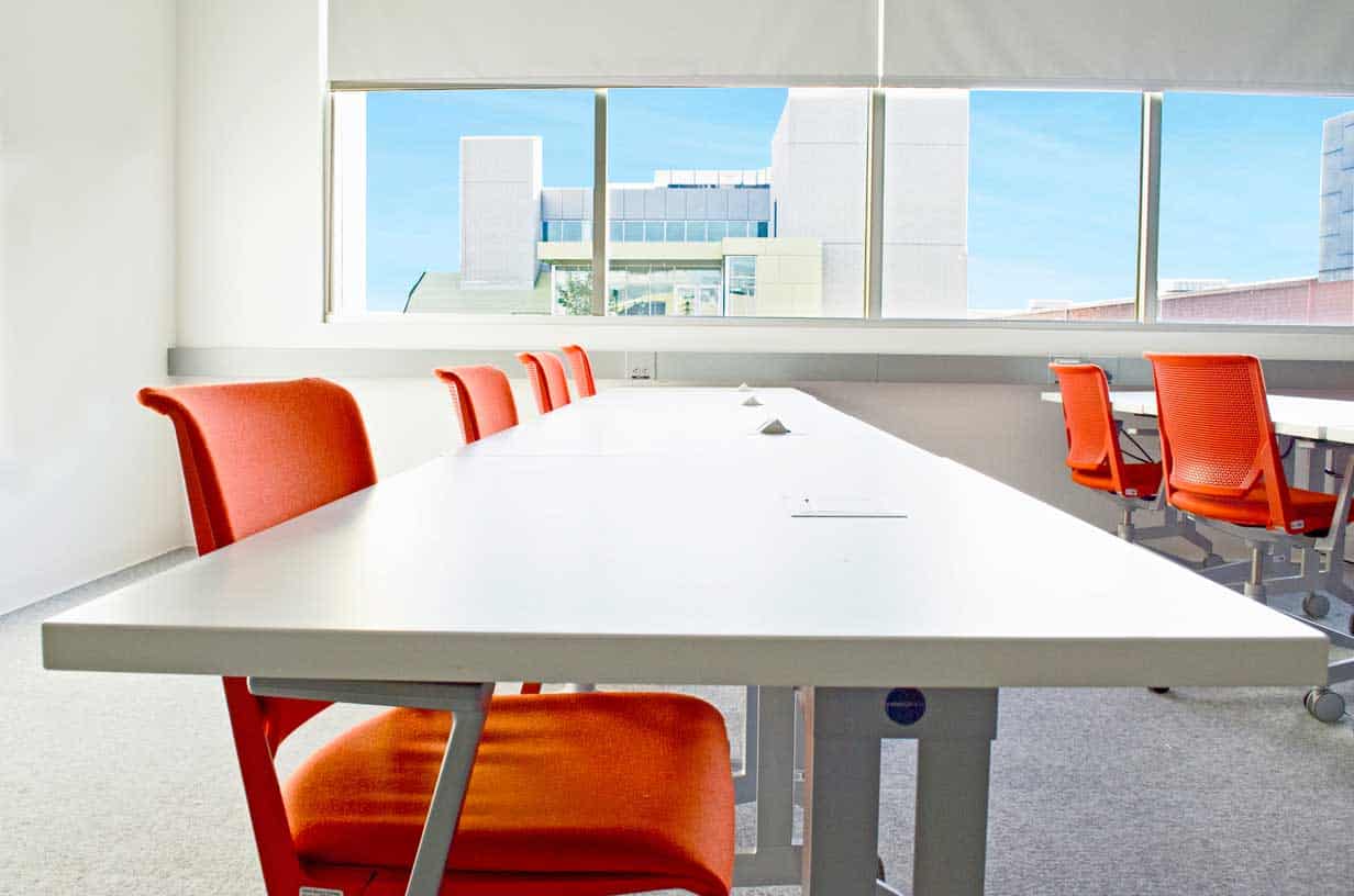 Classroom with Flexible Orange Chairs and White Desks