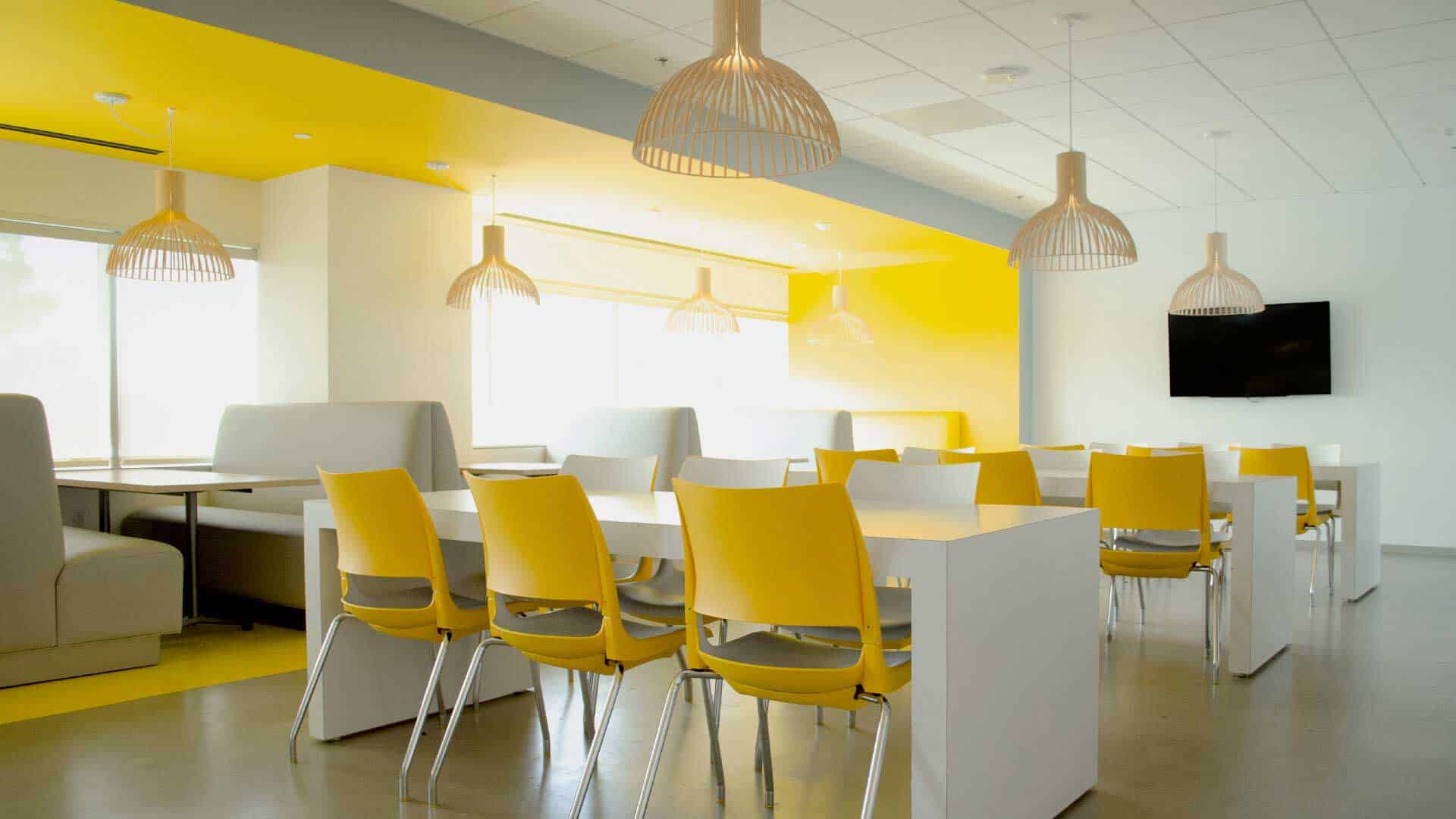 Brightly Colored Open Office Space with Yellow Chairs and White Tables