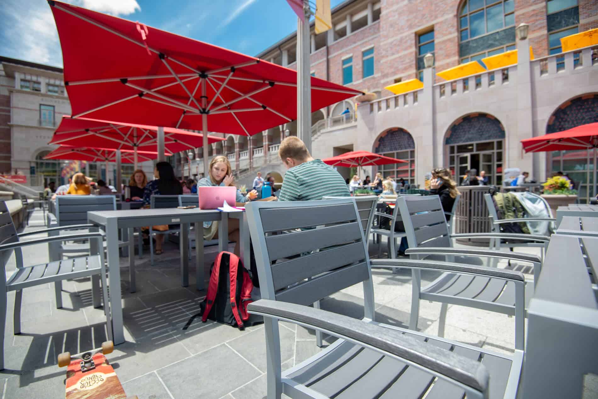 Premium outdoor furniture such as tables, umbrellas, and chairs designed for for high traffic in use by students