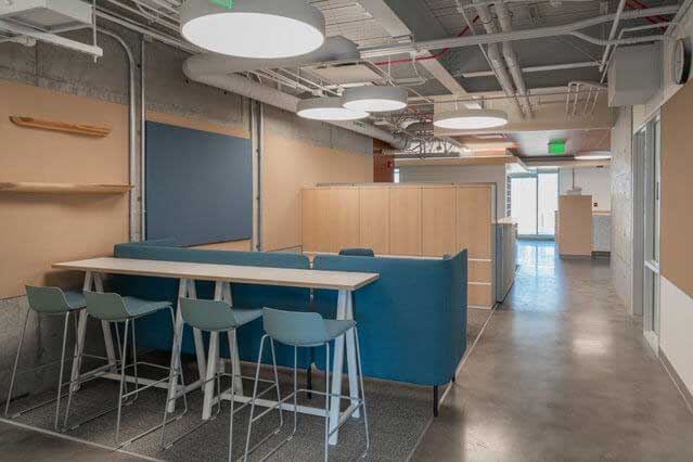 Modern learning lounge design featuring laptop bar and stools