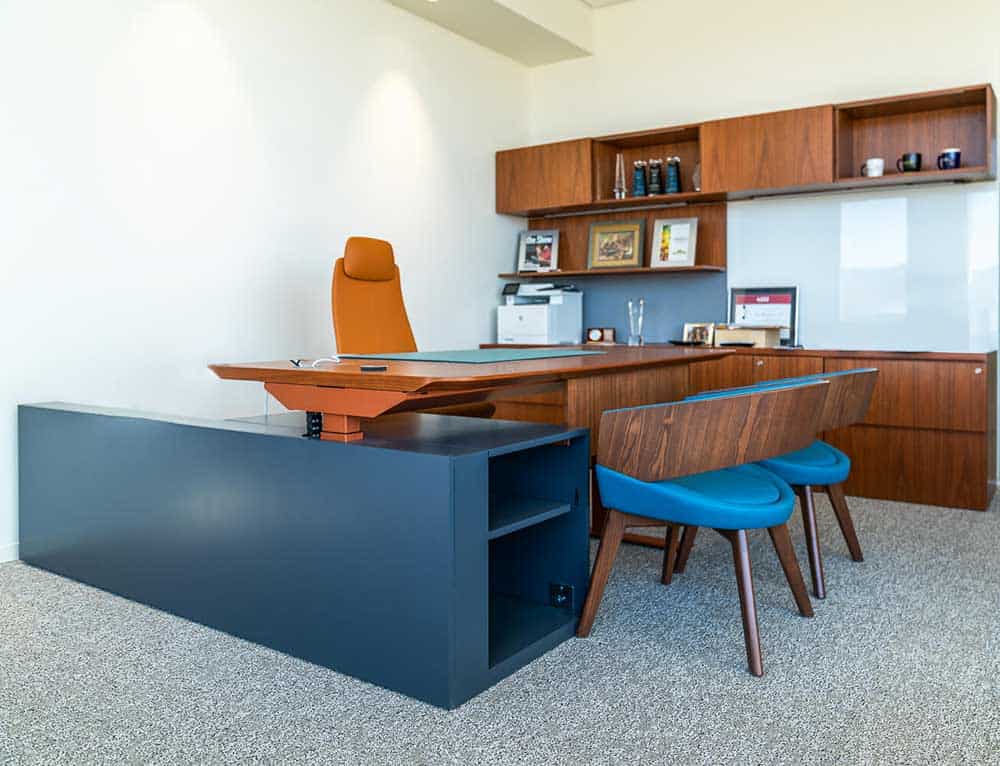 Credit Union executive office features colorful chairs and wood desks