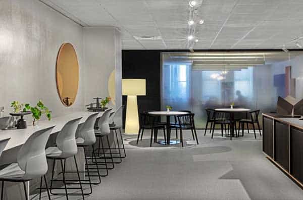 Office interior design Los Angeles showing laptop bar and small tables with chairs