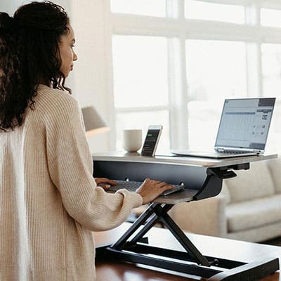 Woman working at standing desk by Haworth Work From Home Products