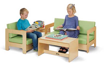 Two wood couches and table with light green upholstery used as a reading nook by two young children from JontiCraft.