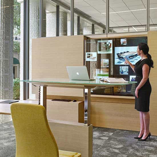 Woman standing next to Haworth’s Bluescape solutions standing desk..